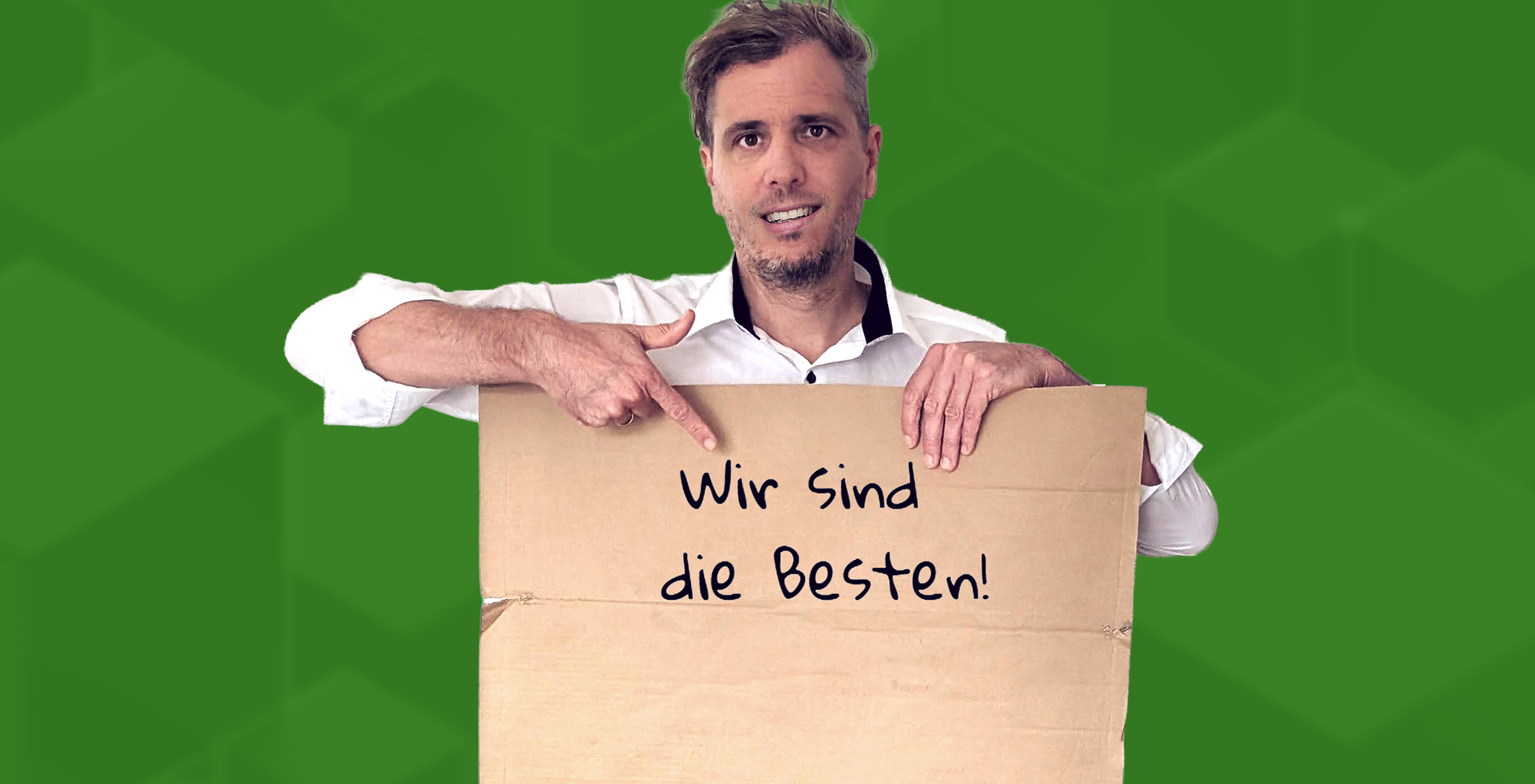Männlich gelesene Person hält sein Papschild mit der Aufschrift "Wir sind die Besten" in die Kamera.