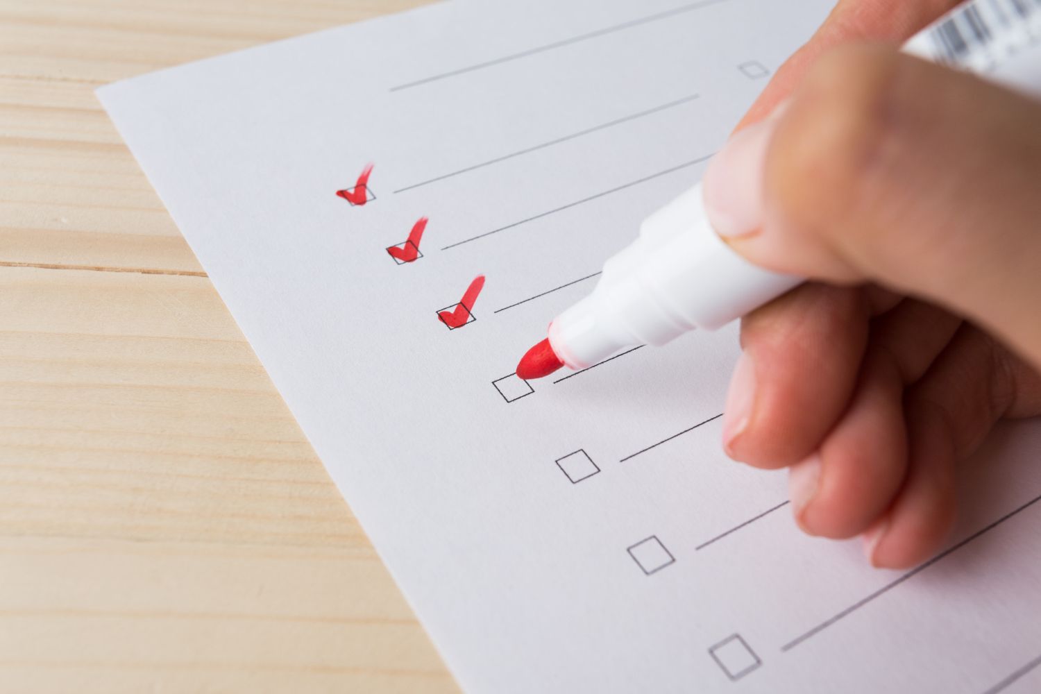 Hand füllt eine Checkliste aus